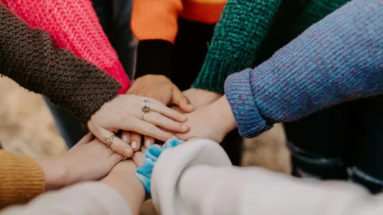 Group of people putting their hands together