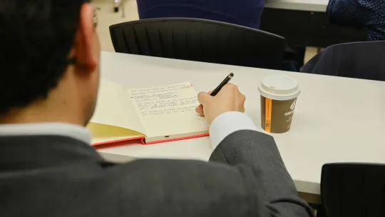 EAE Business School lecturer taking notes