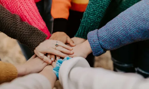 Group of people putting their hands together