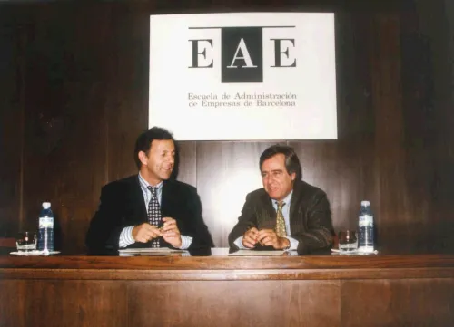 Antiguo logo de la Escuela de Administración de Empresas, presente durante un acto oficial.